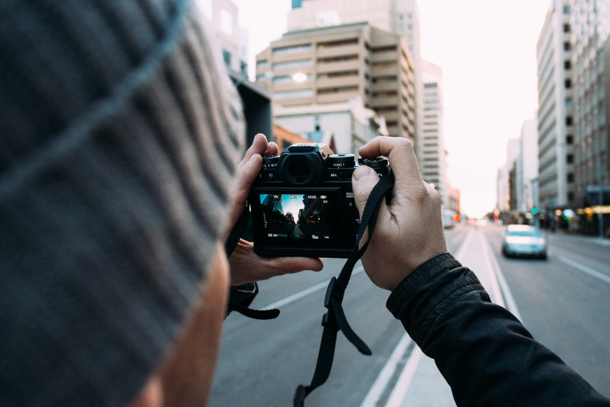 Mann hält Kamera zum Fotografieren