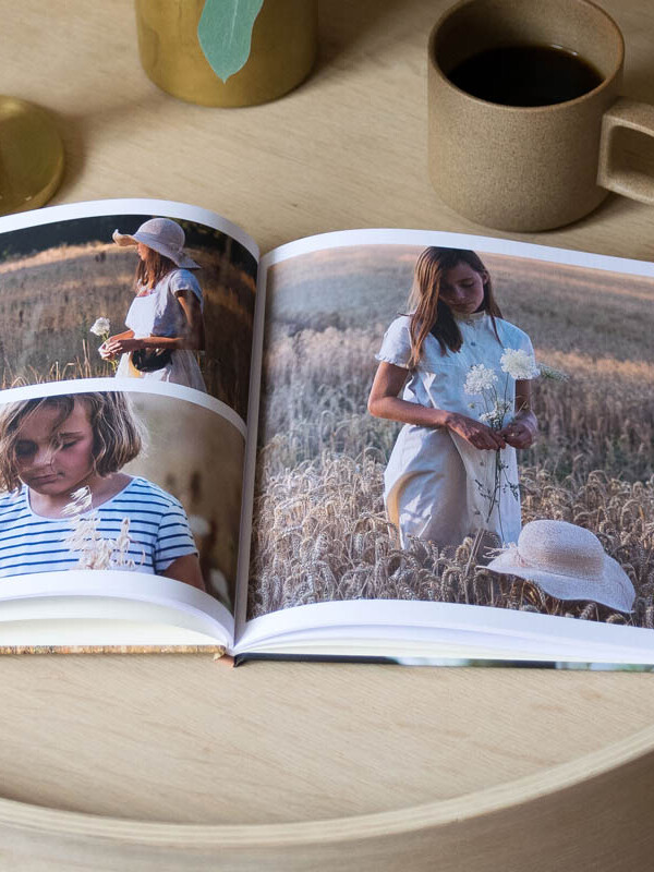 Fotobuch liegt aufgeklappt auf einem Beistelltisch aus Holz