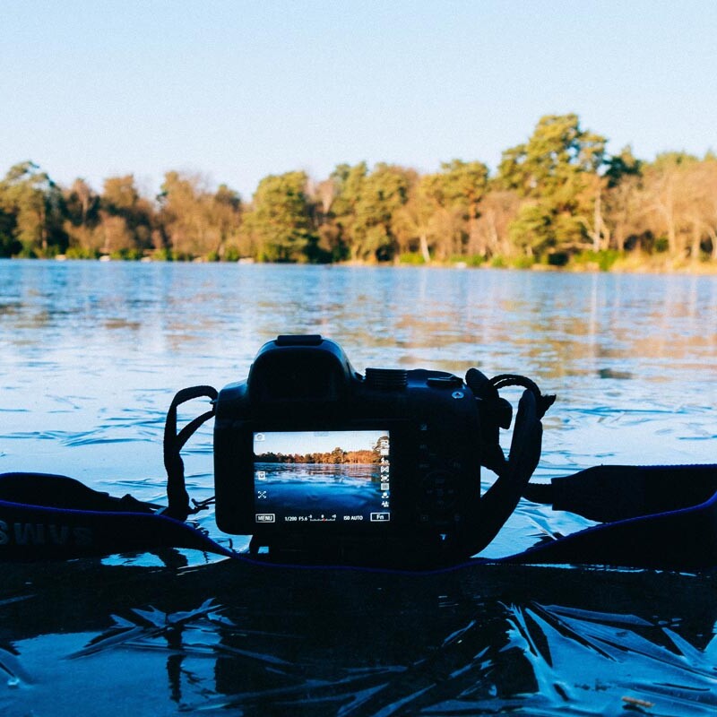 Spiegelreflexkamera liegt auf einem zugefrorenen See
