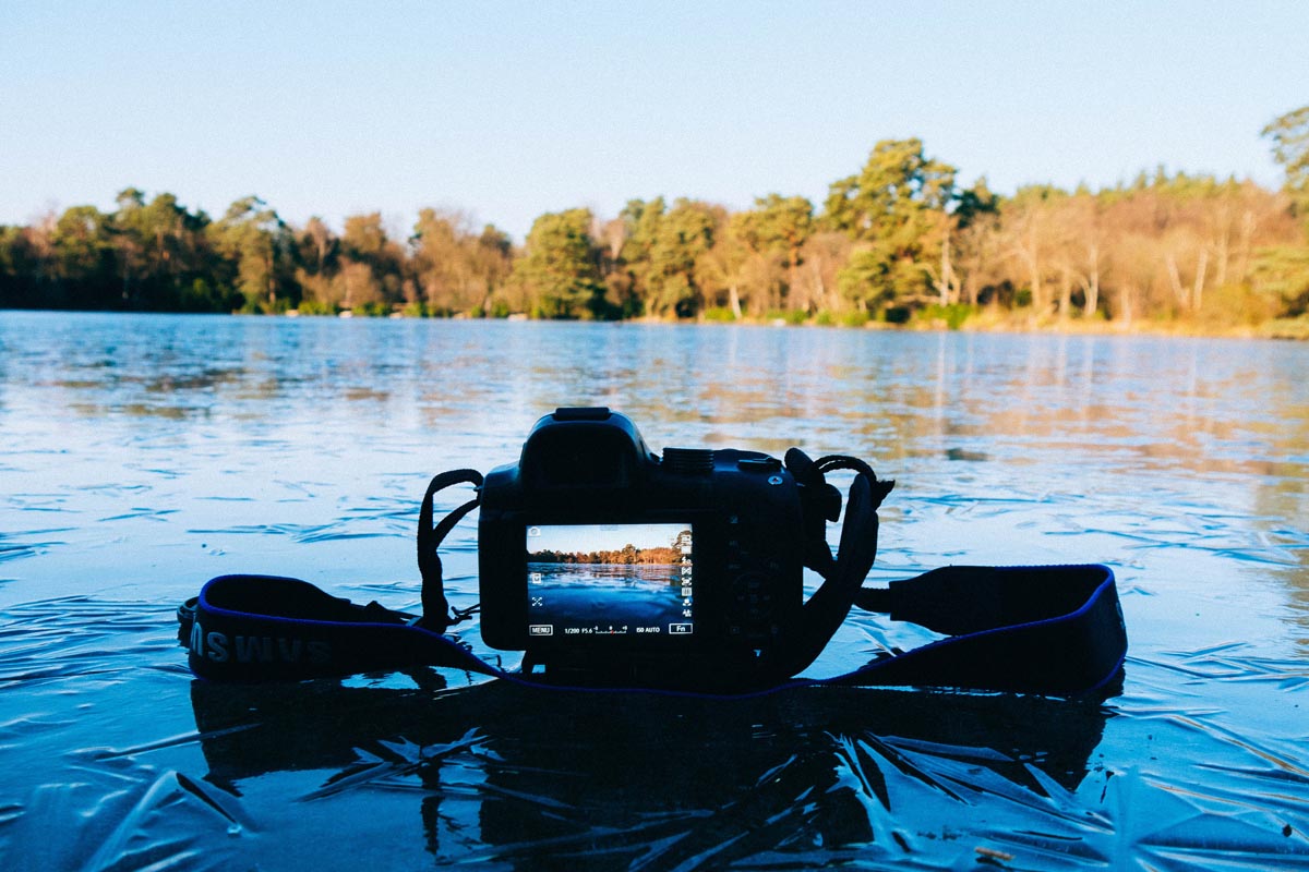 Spiegelreflexkamera liegt auf einem zugefrorenen See